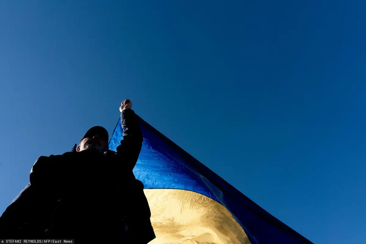 mężczyzna trzyma flagę Ukrainy