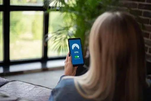 Kobieta w blond włosach trzyma w lewej dłoni smartfon