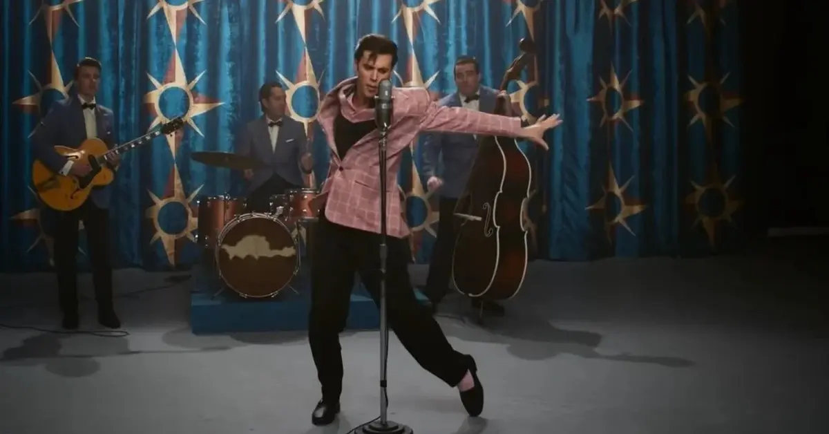 Kadr z filmu: Elvis Presley w czarno-różowym garniturze na scenie