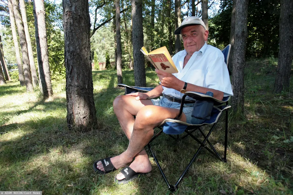 Zbigniew Religa czytający książkę w lesie