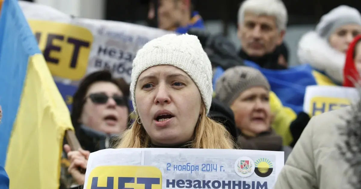 grupa ukraińskich uchodźców z plakatami i flagami