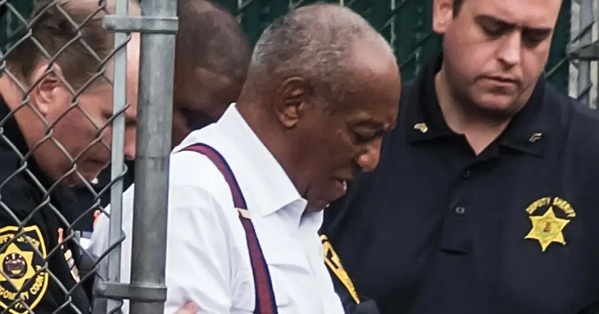 Bill Cosby wsiada do radiowozu.