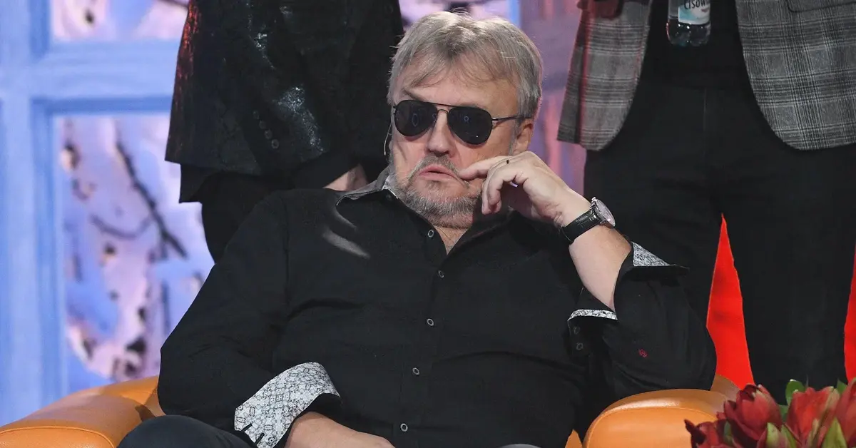 Krzysztof Cugowski siedzi na fotelu.
