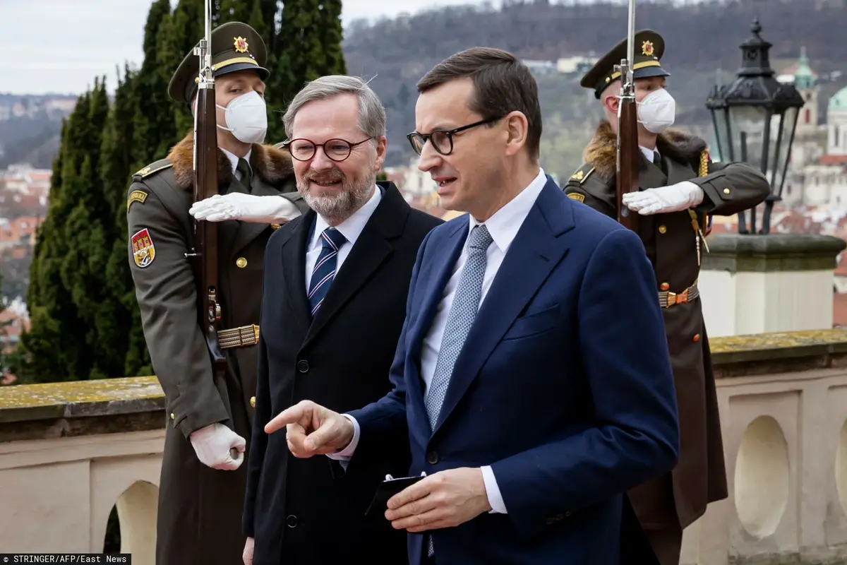 mateusz morawiecki idzie i rozmawia z Petrem Fialą a w tle stoją żołnierze