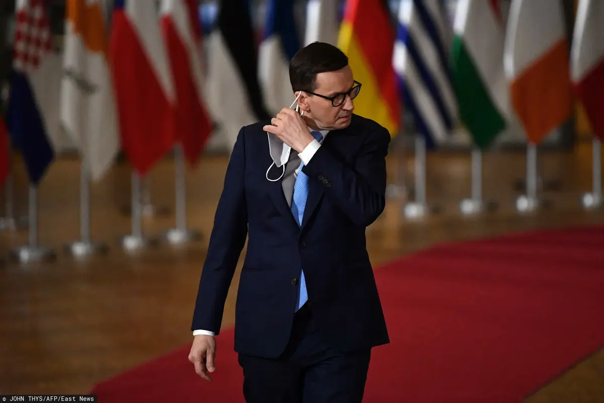 Mateusz Morawiecki zdejmuje maseczkę.