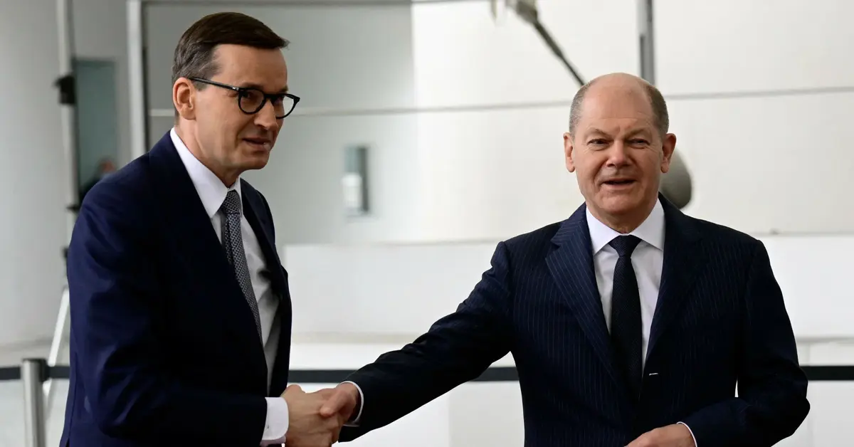 Mateusz Morawiecki podaje rękę Olafowi Scholzowi.