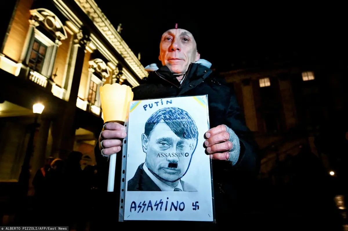 Kobieta trzymająca plakat z Putinem-Hitlerem