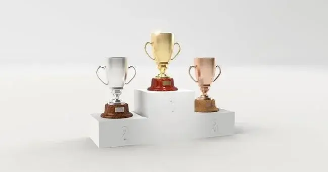 Trzy puchary na podium - złoty, srebrny, brązowy