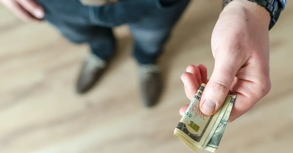 Mężczyzna trzyma w dłoni banknot