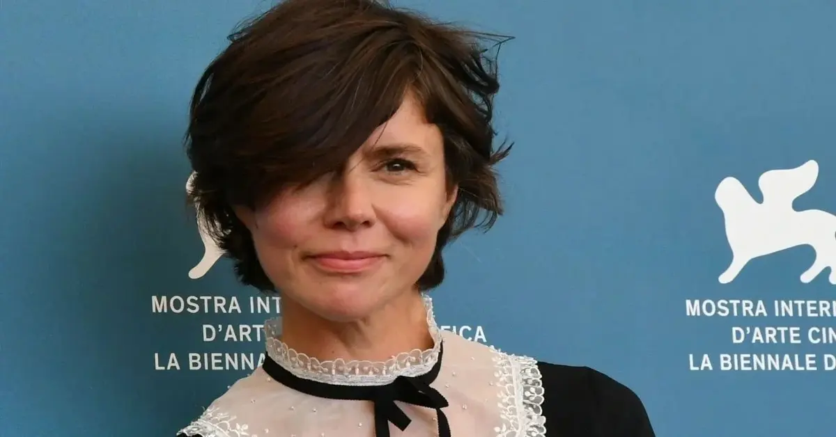Małgorzata Szumowska w czarno-białej bluzce na niebieskim tle