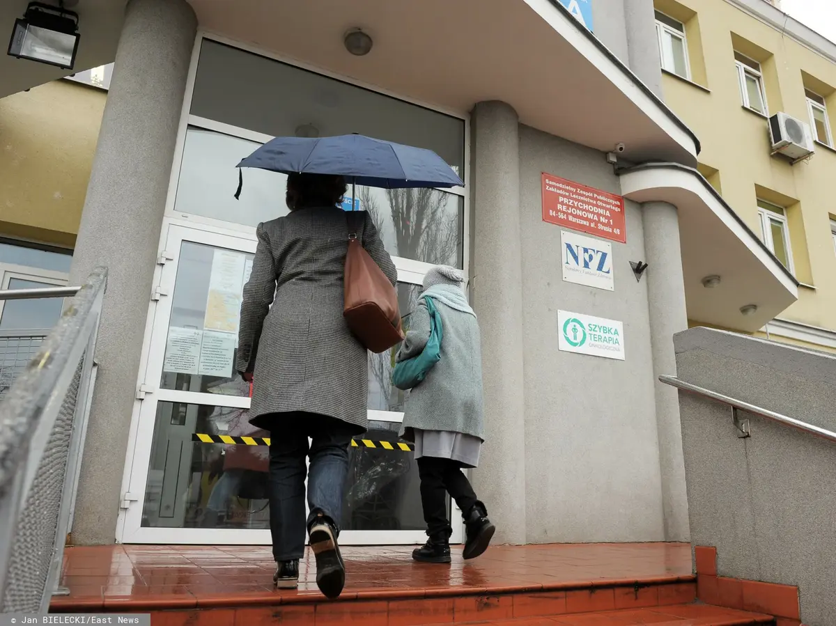Dwie osoby przed wejściem do warszawskiej przychodni