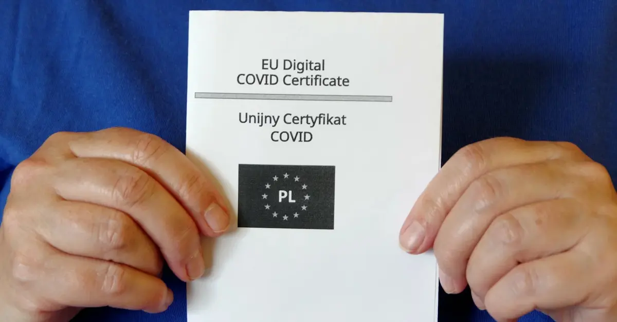 Unijny Certyfikat COVID trzymany w rękach