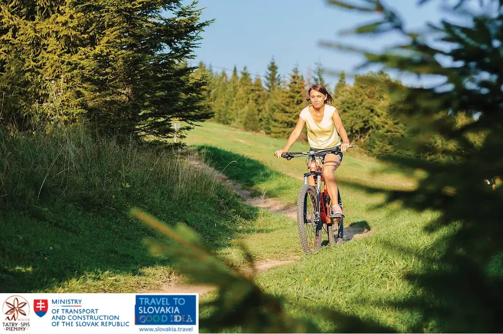 Rowerzystka na wycieczce w pięknych górach jedzie ścieżką rowerową Region Tatry - Spisz - Pieniny