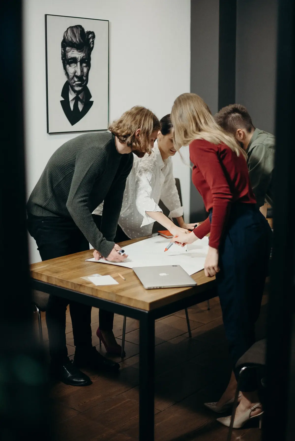 Zespół młodych ludzi omawia projekt przy stole