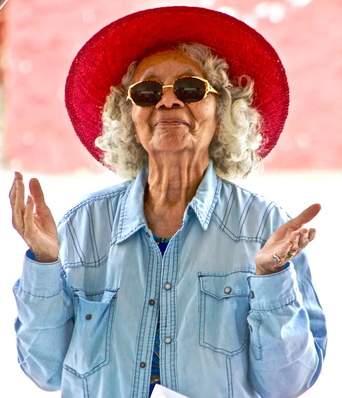 Seniorka w czerwonym kapeluszu i okularach
