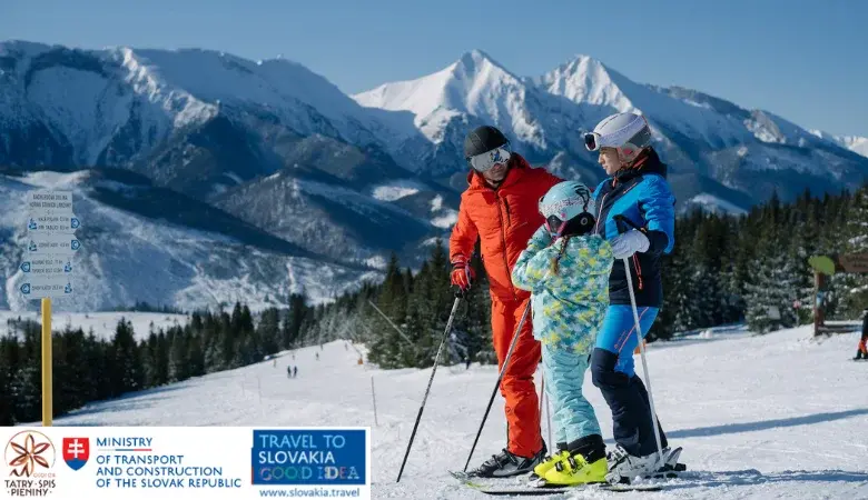 Rodzina narciarzy w kolorowych ubraiach na tle słowackich Pienin szykuje się do zjazdu po zaśnieżonym stoku na nartach