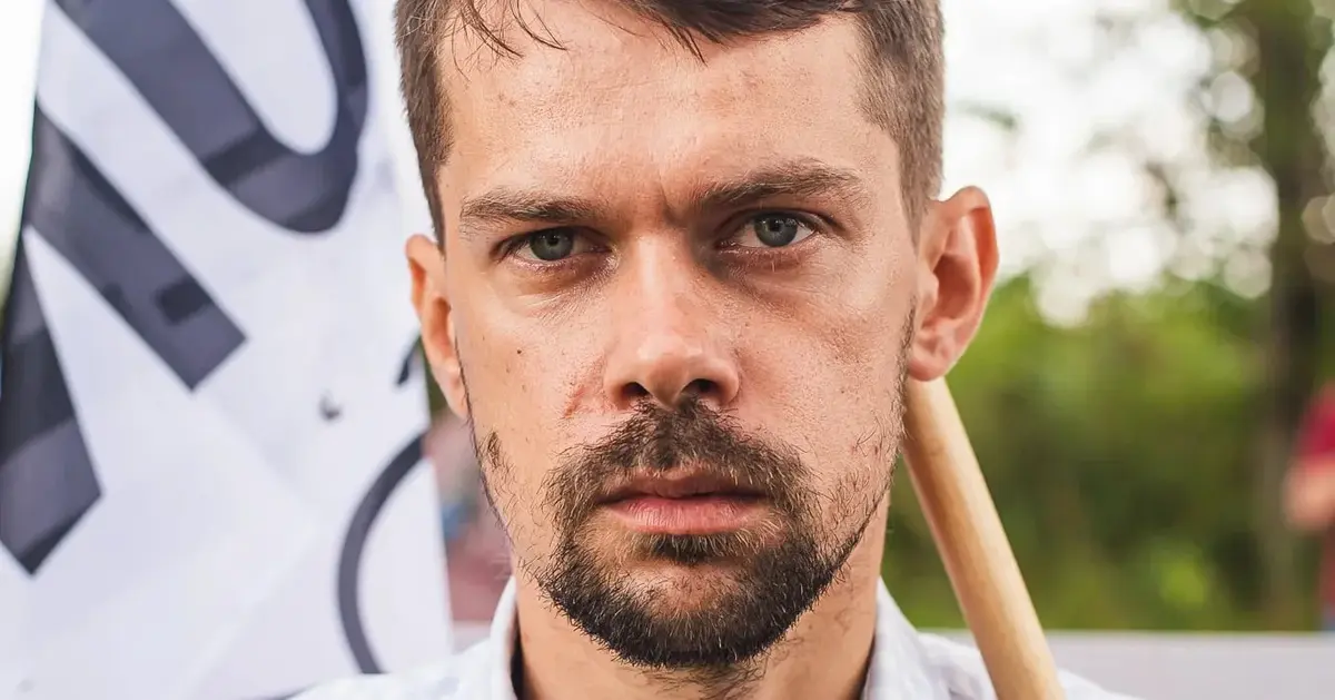 michał kołodziejczak, lider agrounii, w koszuli i z flagą swojej partii podczas demonstracji