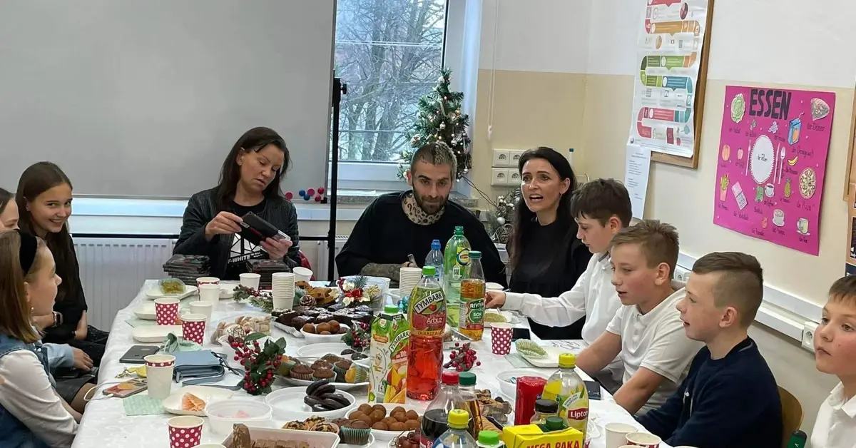 Raper Quebonafide w otoczeniu dzieci na wigilii klasowej.