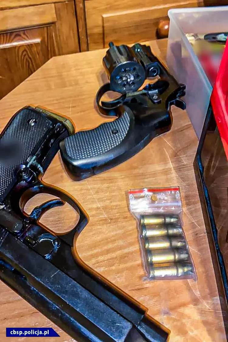 Dwa pistolety leżące na blacie oraz naboje w plastikowym woreczku