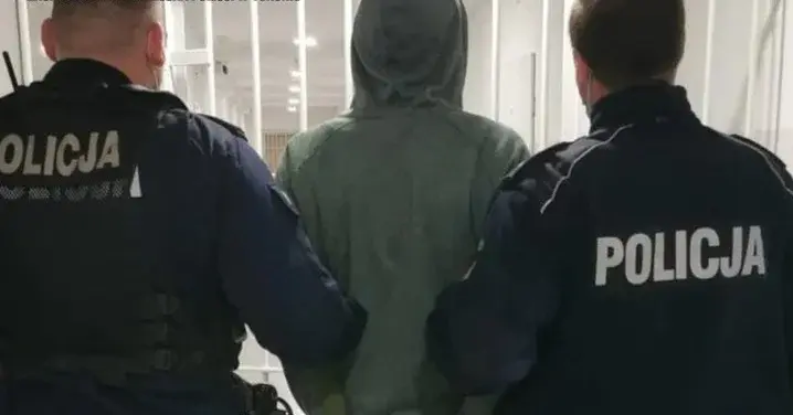 zakapturzony mężczyzna tyłem prowadzony przez dwóch policjantów