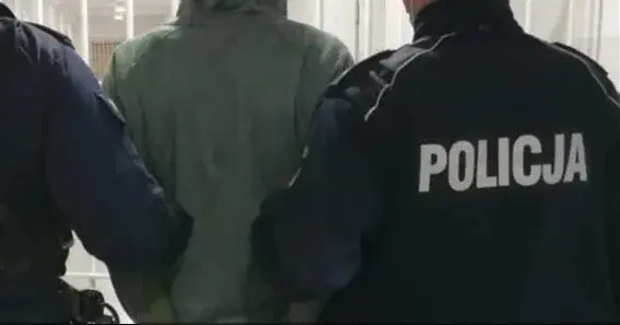 zakapturzony mężczyzna tyłem prowadzony przez dwóch policjantów
