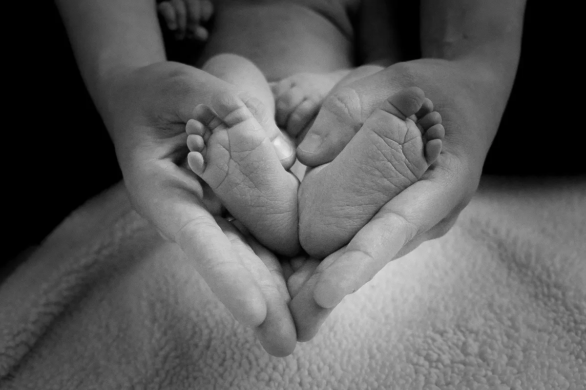 stópki noworodka i dłonie matki