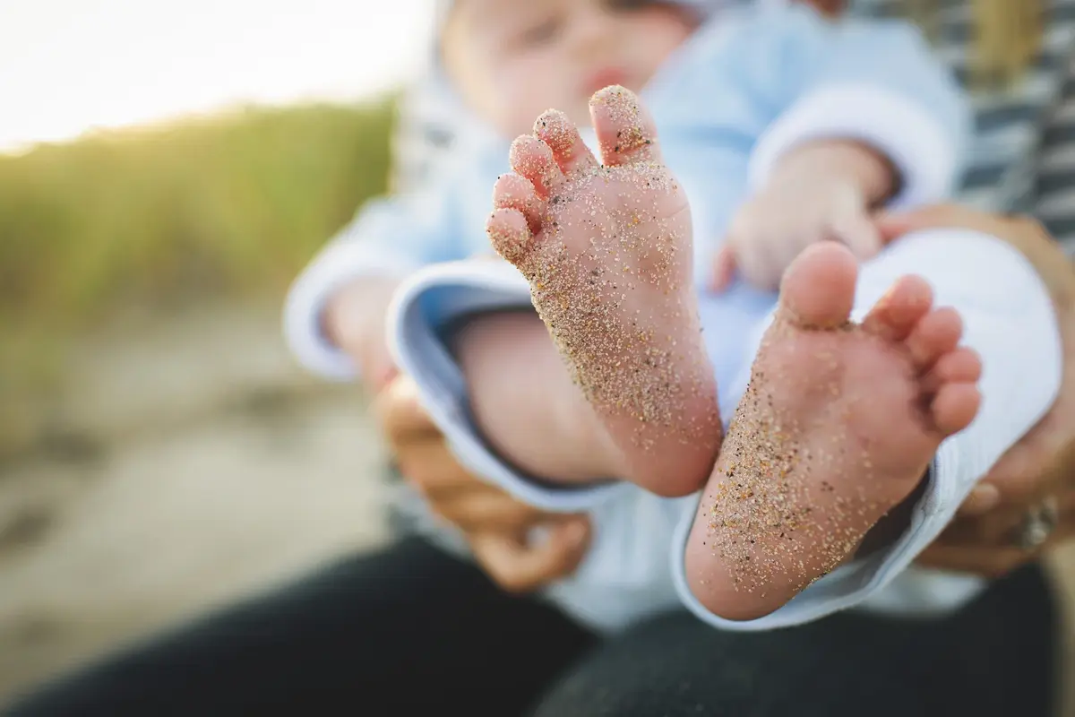 stópki małego dziecka ubrudzone w piasku