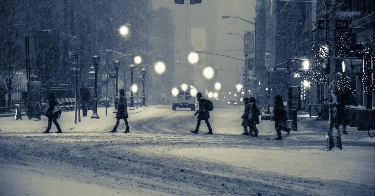 ulica, którą przechodzą ludzie w zimowej aurze