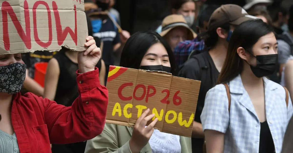 COP26 - kobieta trzymająca tabliczkę z napisem COP 26 Act Now