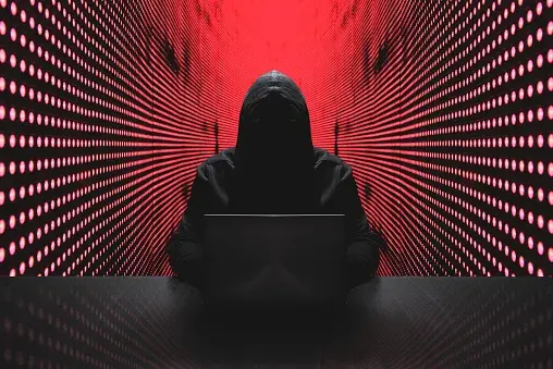 Mężczyzna w kapturze przypominający hakera w trakcie cyberataku
