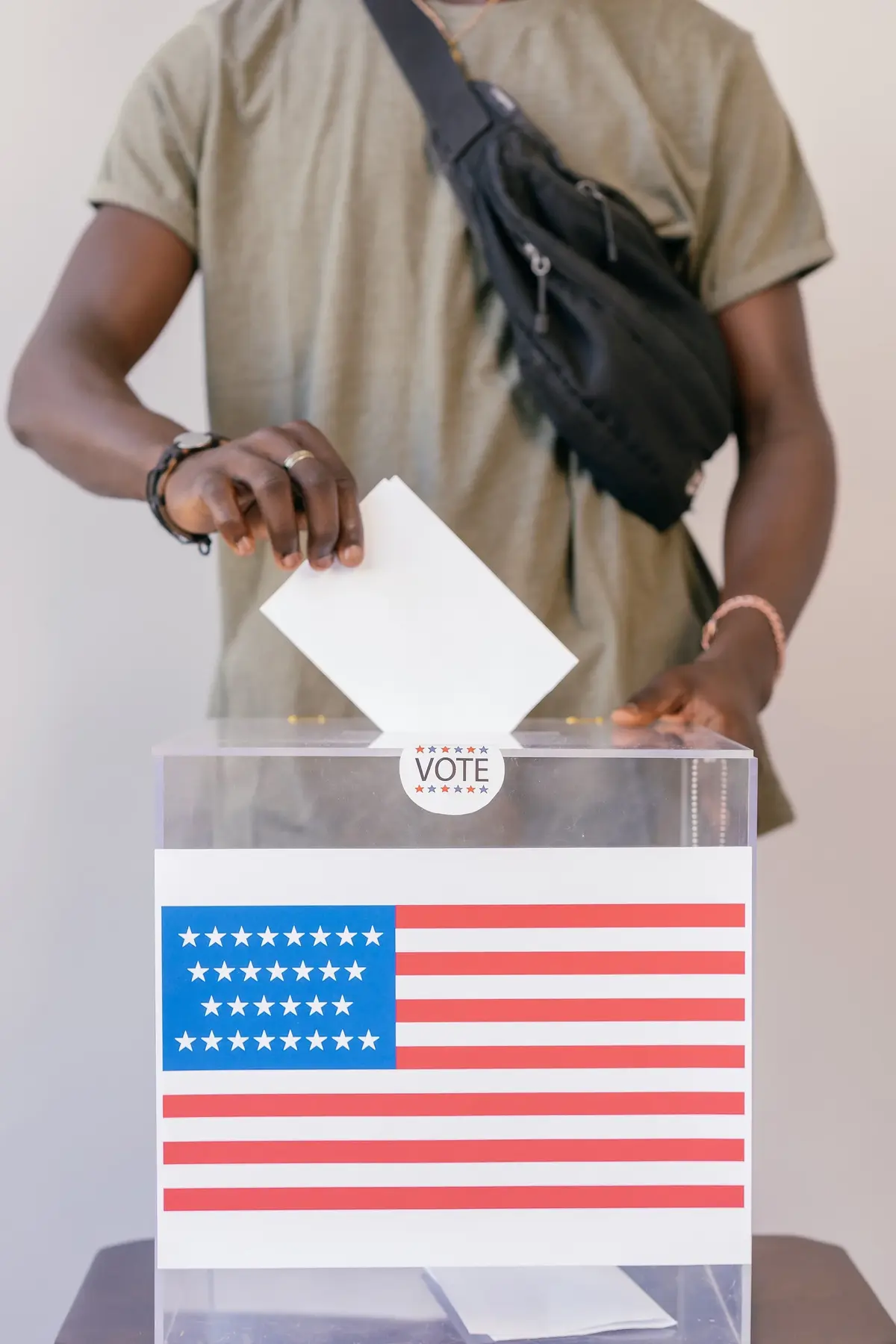 Mężczyzna wrzuca kartę wyborczą do urny
