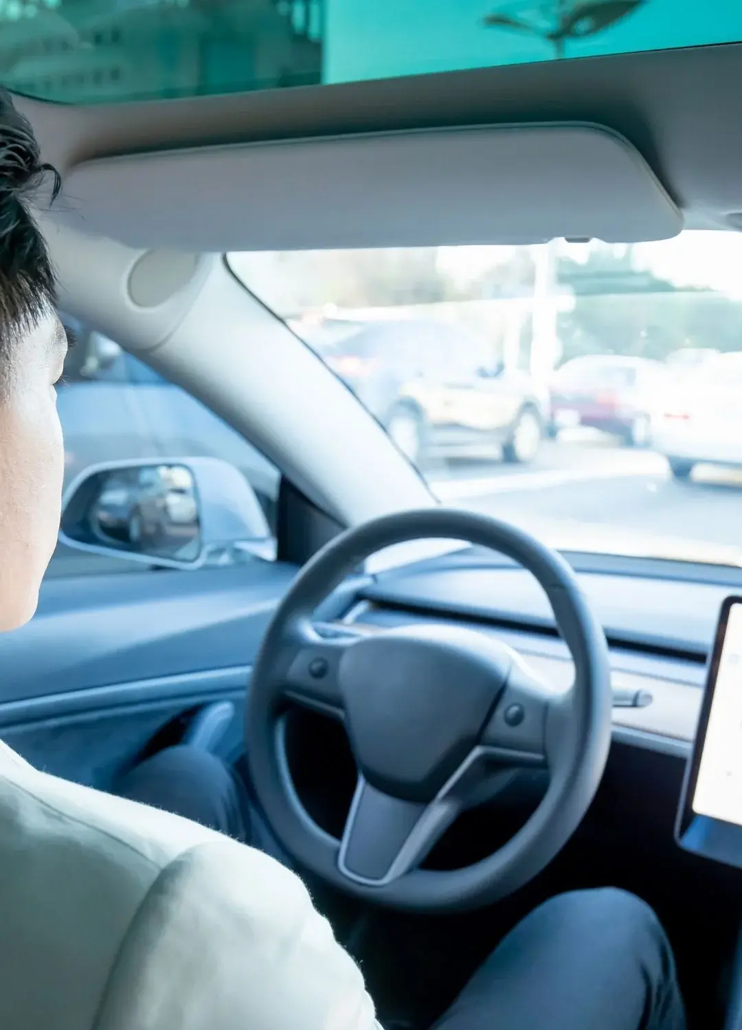 Osoba siedząca za kierownicą pojazdu autonomicznego podczas ruchu, która nie trzyma rąk na kierownicy