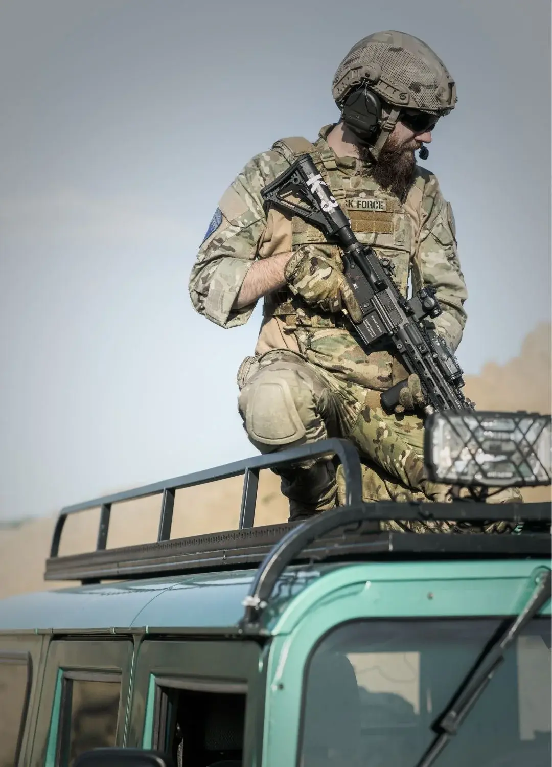 Uzbrojony żołnierz na dachu pojazdu