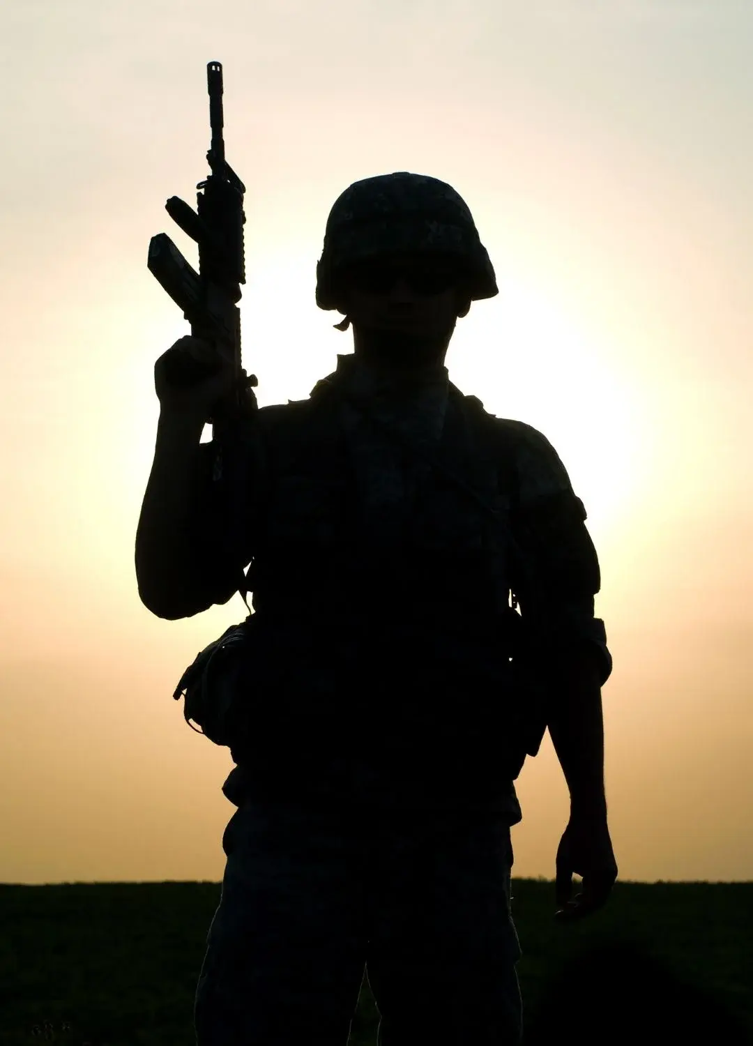 Sylwetka uzbrojonego żołnierza na tle zachodu słońca