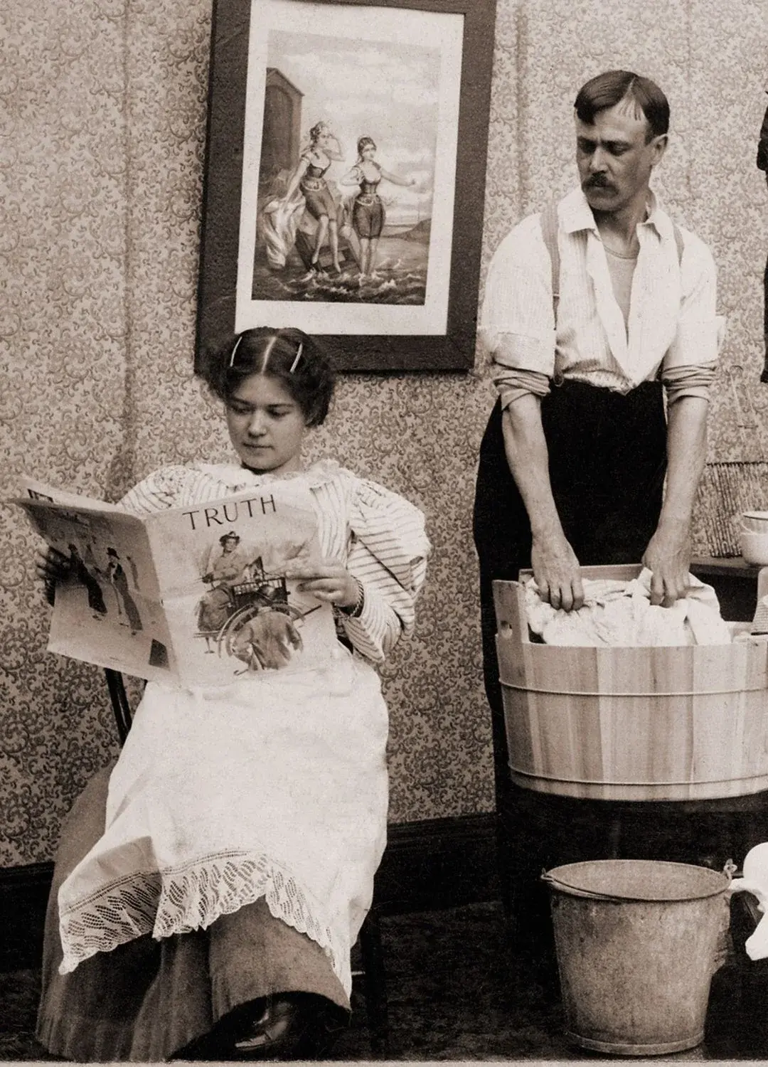 Kobieta czytająca magazyn i mężczyzna robiący pranie