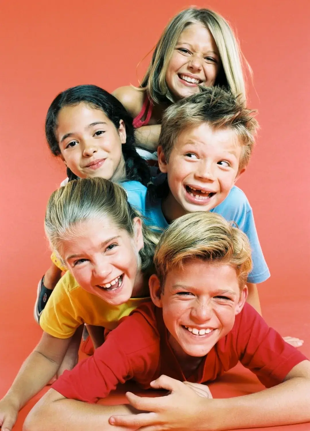 Piątka uśmiechniętych dzieci na morelowym tle