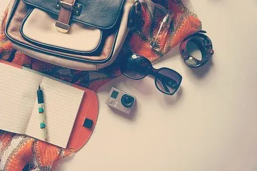 Plecak z rzeczami do pakowania, w tym aparatem fotograficznym oraz okularami przeciwsłonecznymi