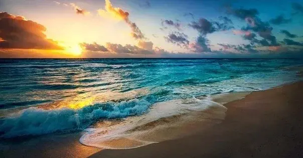 Widok na plażę, morze i chmury, w trakcie zachodu słońca