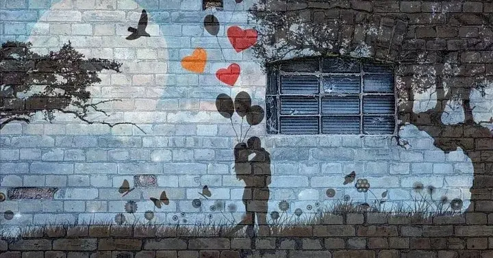 Mural przedstawiający zakochaną parę, serduszka, drzewo i księżyc 