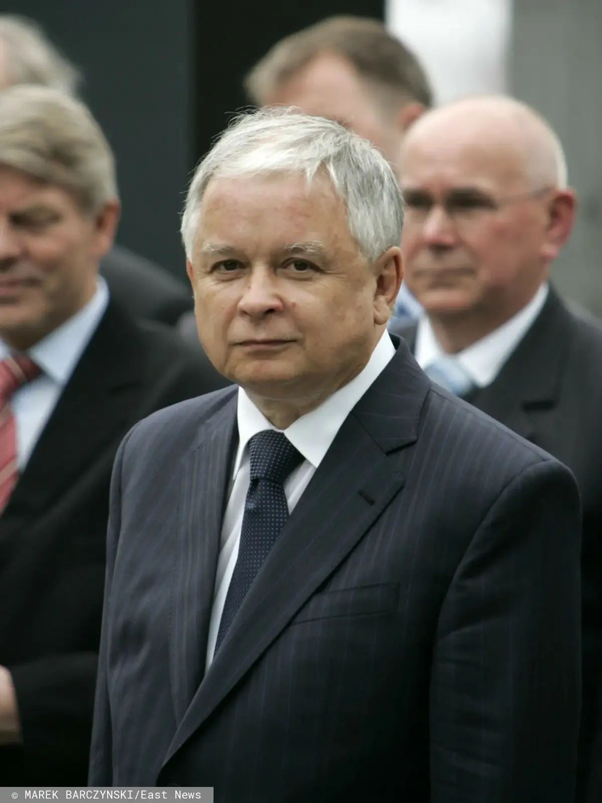 Lech Kaczyński w garniturze spoglądający przed siebie