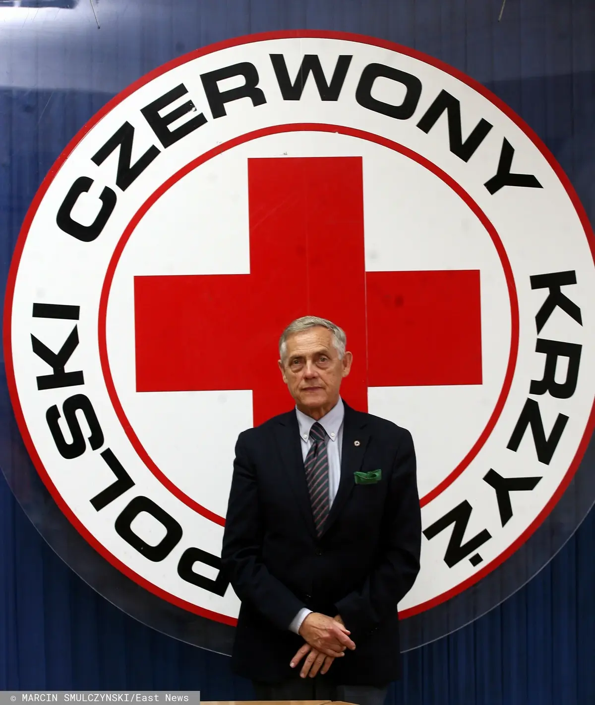 Jerzy Kotowicz na tle logo PCK