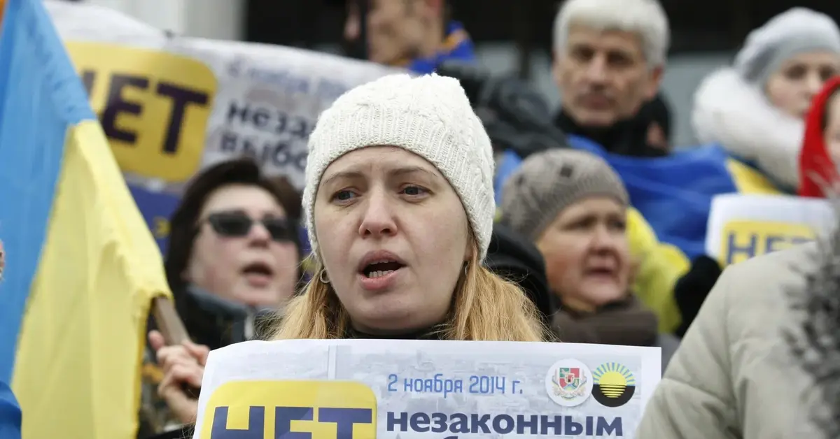 grupa ukraińskich uchodźców z plakatami i flagami