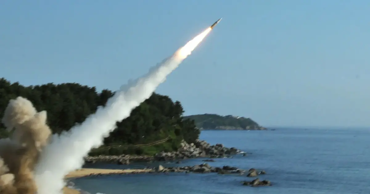 pocisk rakietowy wystrzelony z wyrzutni tuż przy brzegu leci nad wodą i skałami wybrzeża