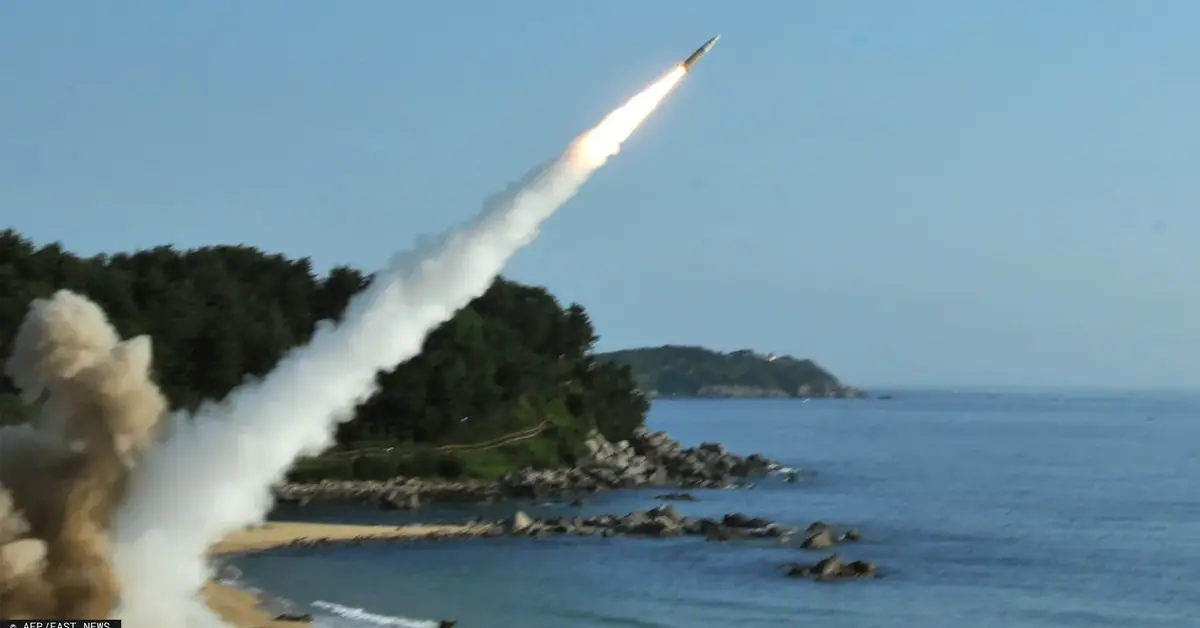 pocisk rakietowy wystrzelony z wyrzutni tuż przy brzegu leci nad wodą i skałami wybrzeża