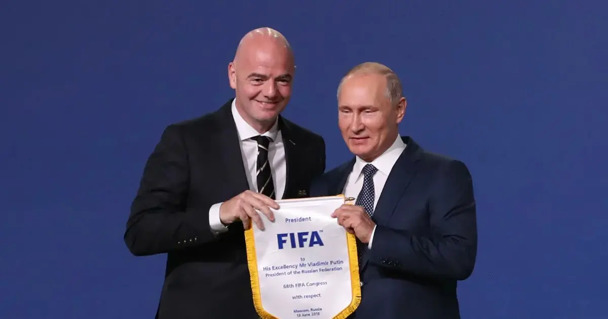 Gianni Infantino i Władimir Putin trzymają proporczyk FIFA