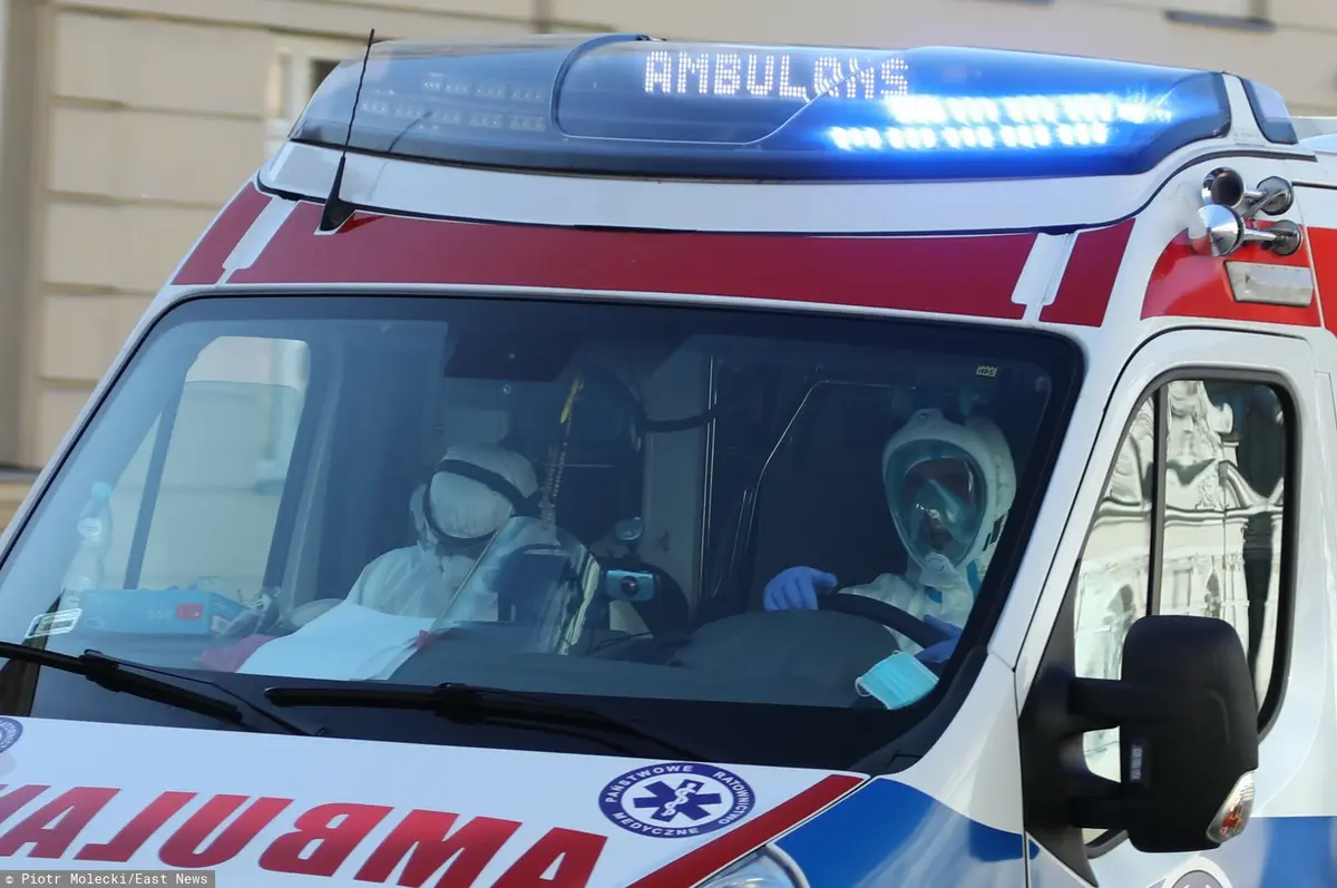 karetka pogotowia z ratownikami jedzie do chorych na koronawirusa