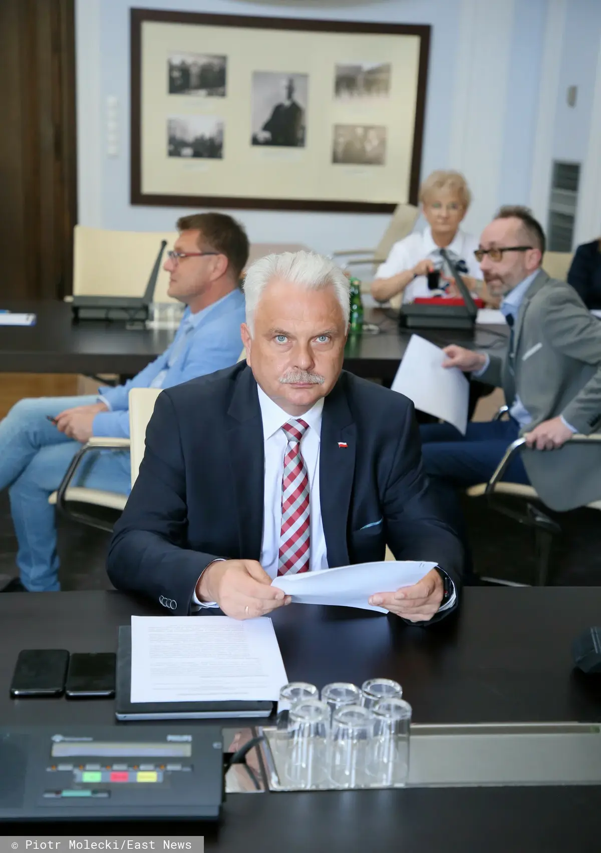 Waldemar Kraska siedzi przy stole z dokumentami