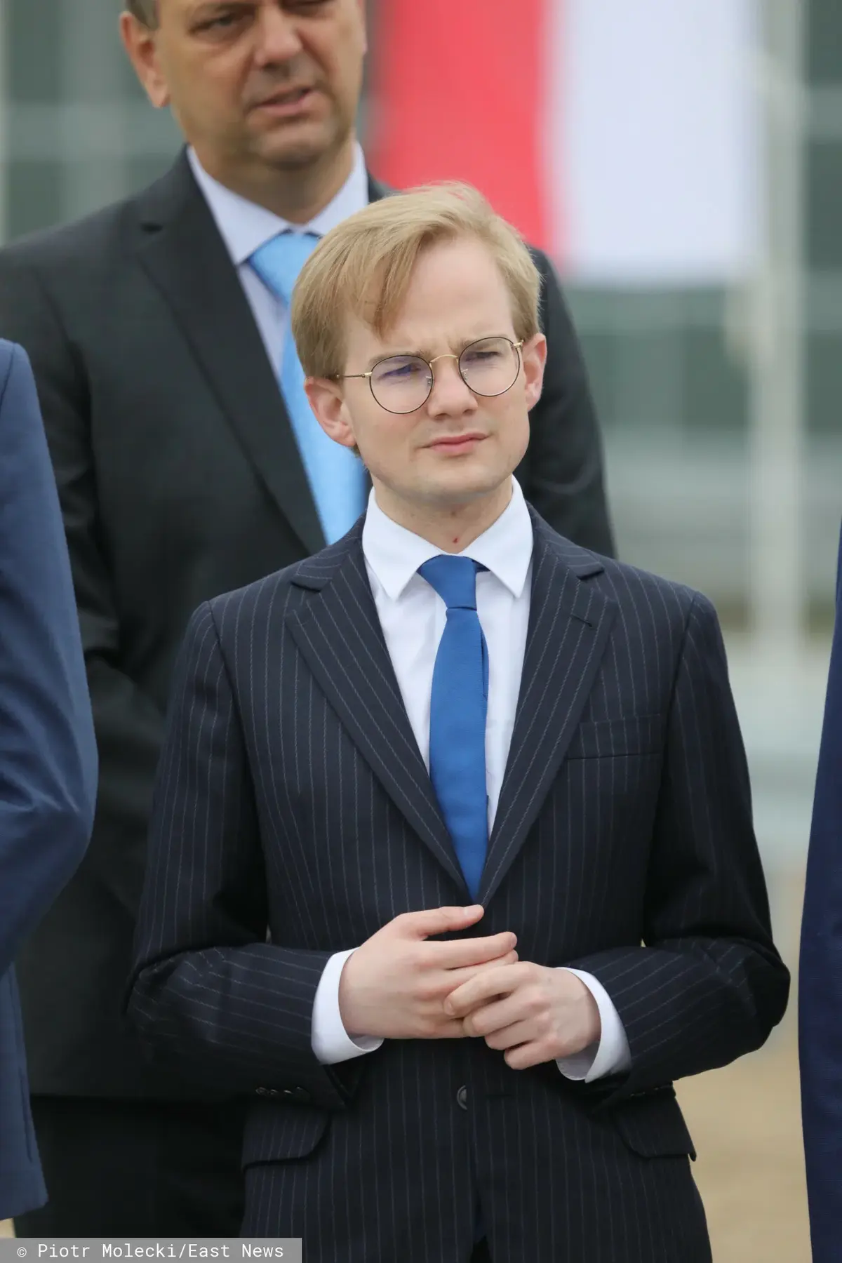 Piotr Patkowski w garniturze i niebieskim krawacie
