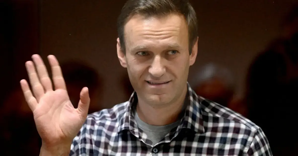 Aleksiej Nawalny w kraciastej koszuli macha do obiektywu