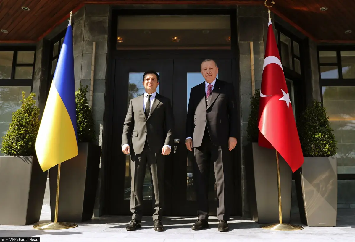 Zełenski i Erdogan w garniturach przy flagach swoich krajów.